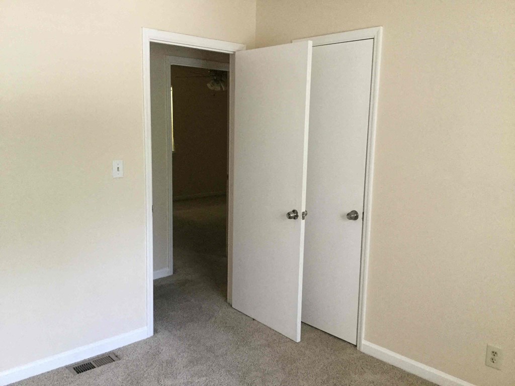 a room with two closets and a door to a hallway