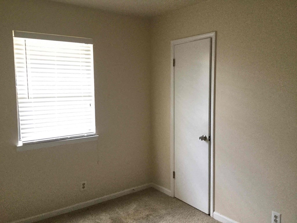 an empty room with a window and a door