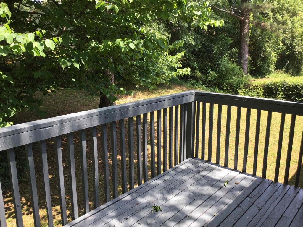 a deck with a view of a yard and trees