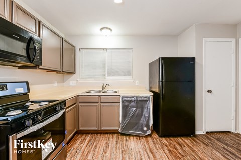 a kitchen with stainless steel appliances and a black refrigerator