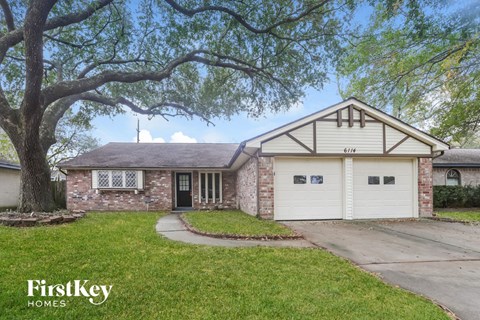 a brick house with a large tree in front of it