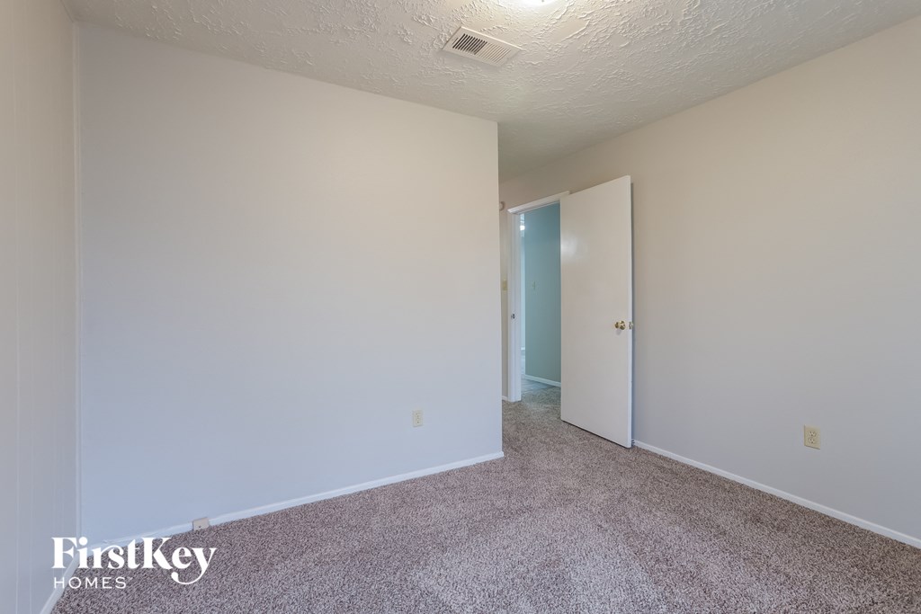 a bedroom with a carpeted floor and white walls