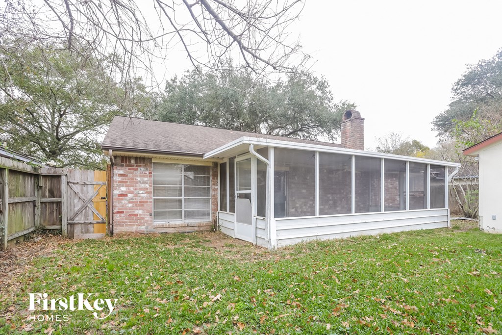 the back of a house with a porch and a screened in porch