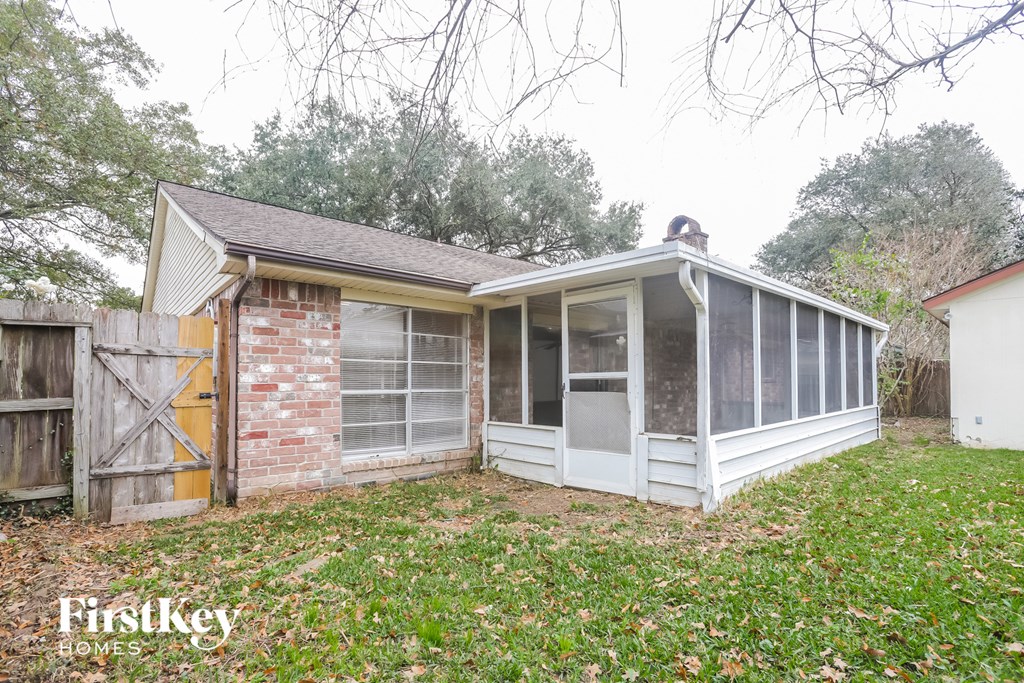 the backyard of a small house with a porch and a conservatory
