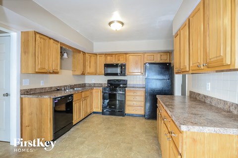 A kitchen with wooden cabinets and black appliances.