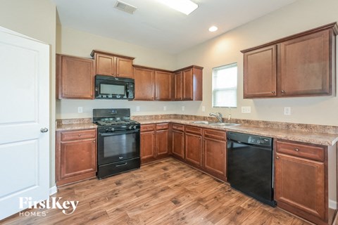 a kitchen with wood flooring and wooden cabinets