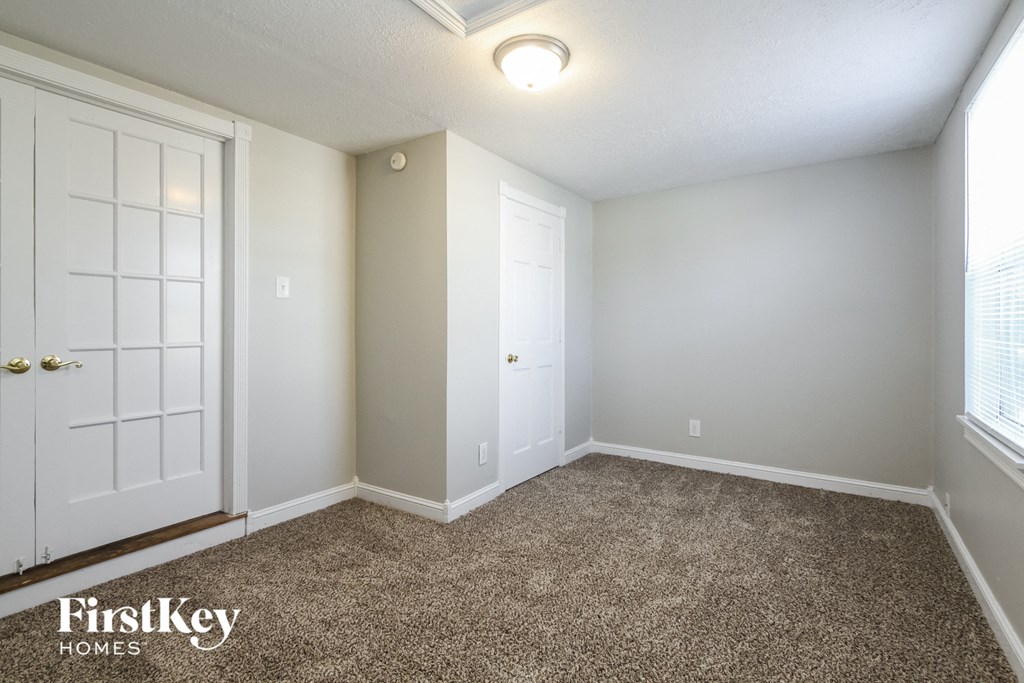 a bedroom with a carpeted floor and a door to a closet