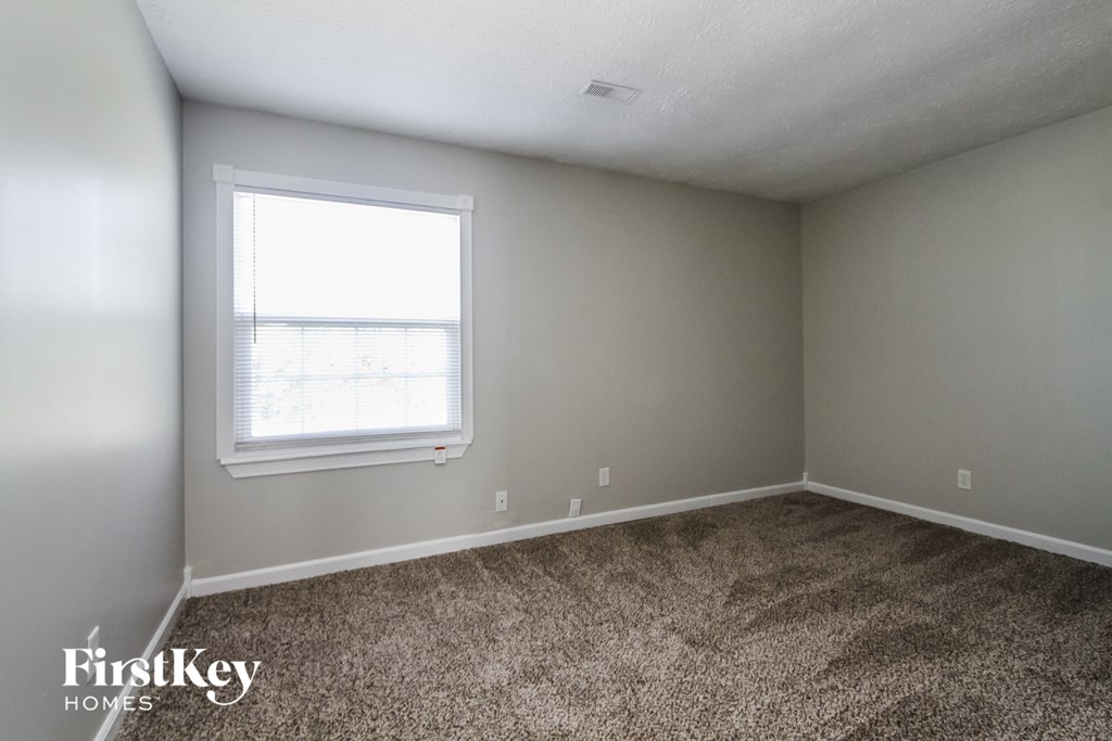 a bedroom with carpet and a window