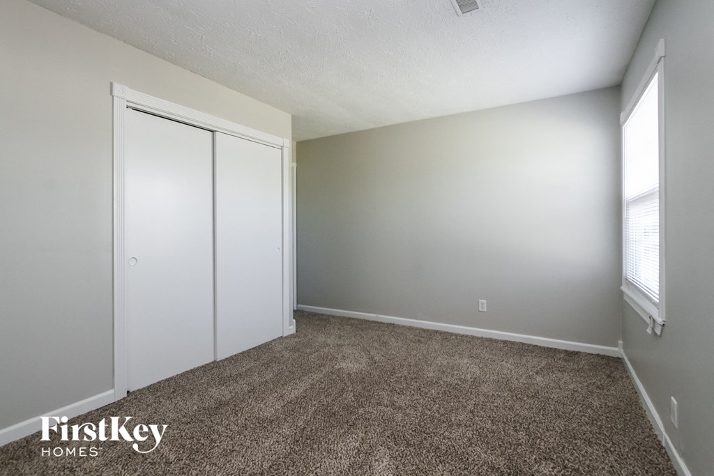 a bedroom with a carpeted floor and white closet doors