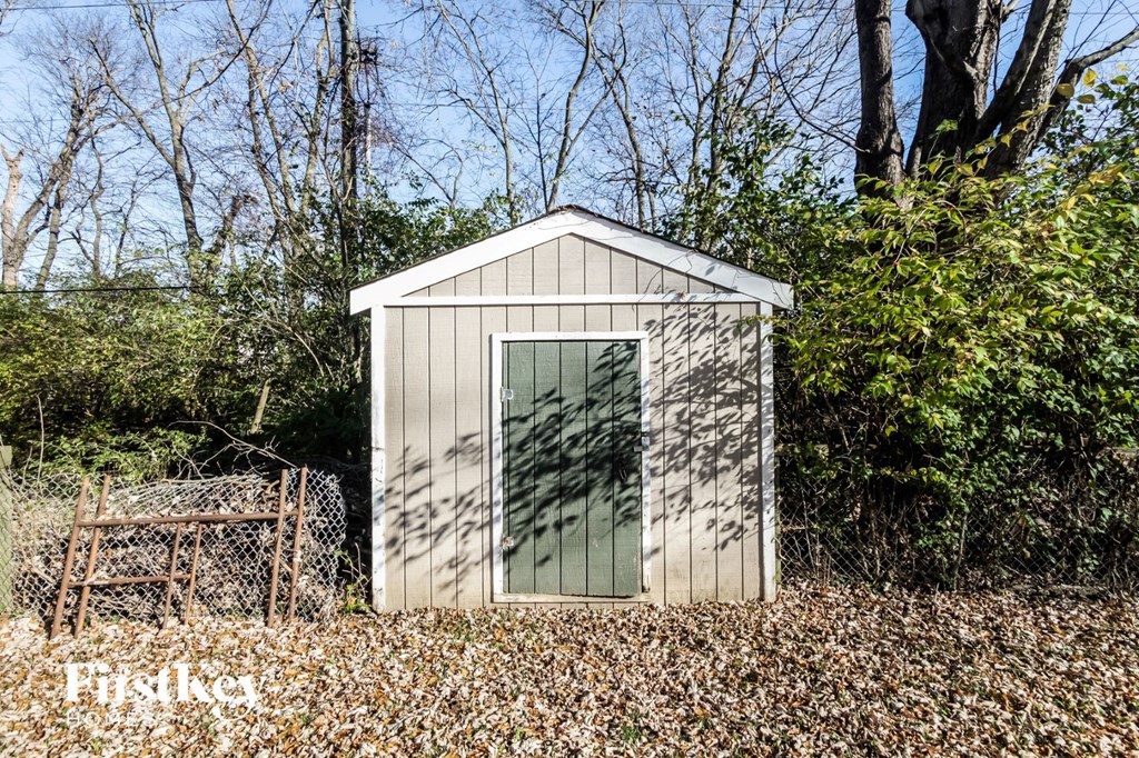 a small wooden shed in the middle of the woods