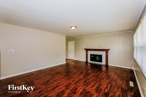 A room with a fireplace and wooden floors.