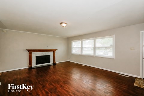 A room with a fireplace and wooden floors.