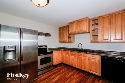 A kitchen with wooden cabinets and a stainless steel refrigerator.
