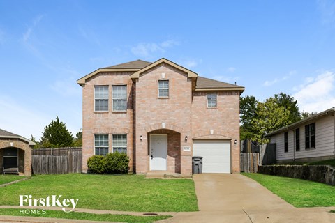 A brick house with a garage is for sale.