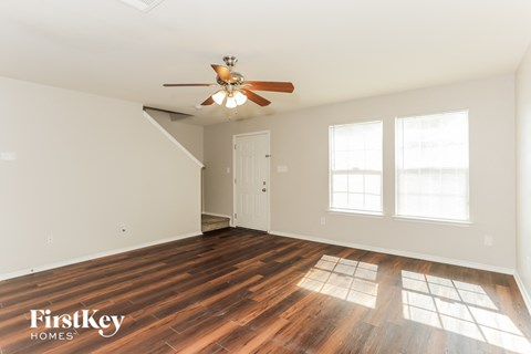 A room with a wooden floor and a ceiling fan.