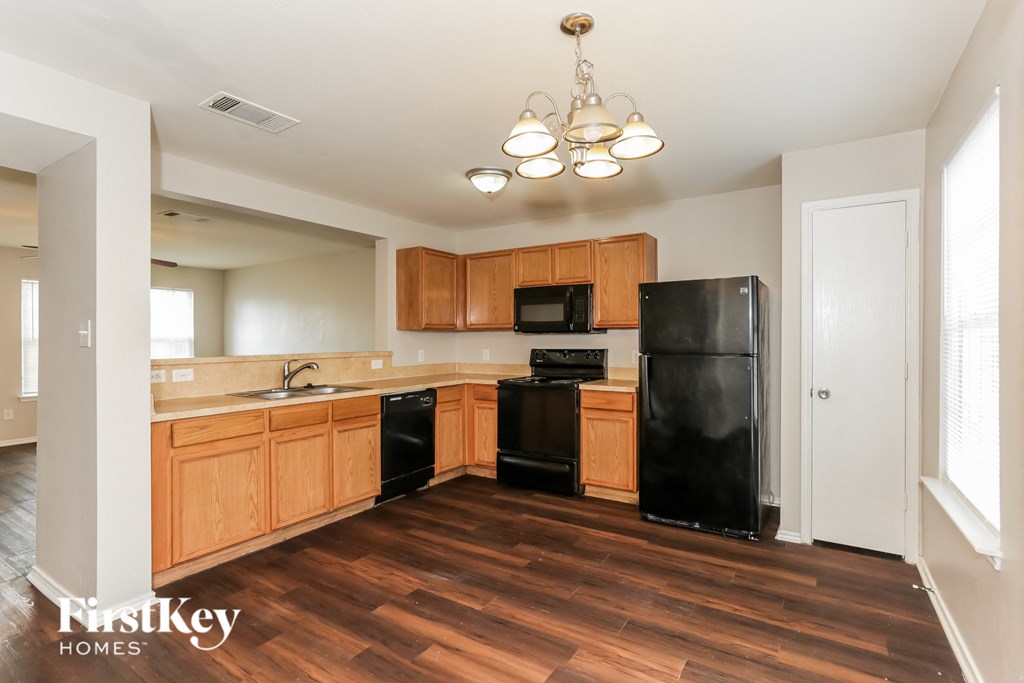 A kitchen with wooden cabinets and black appliances.
