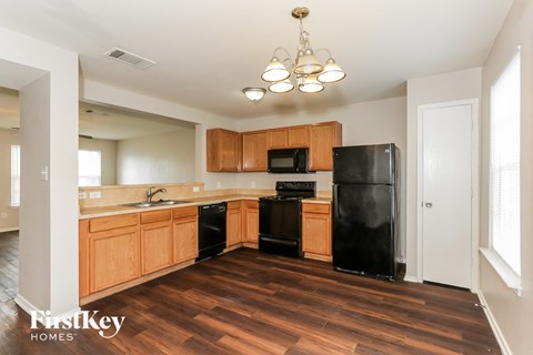 A kitchen with wooden cabinets and black appliances.