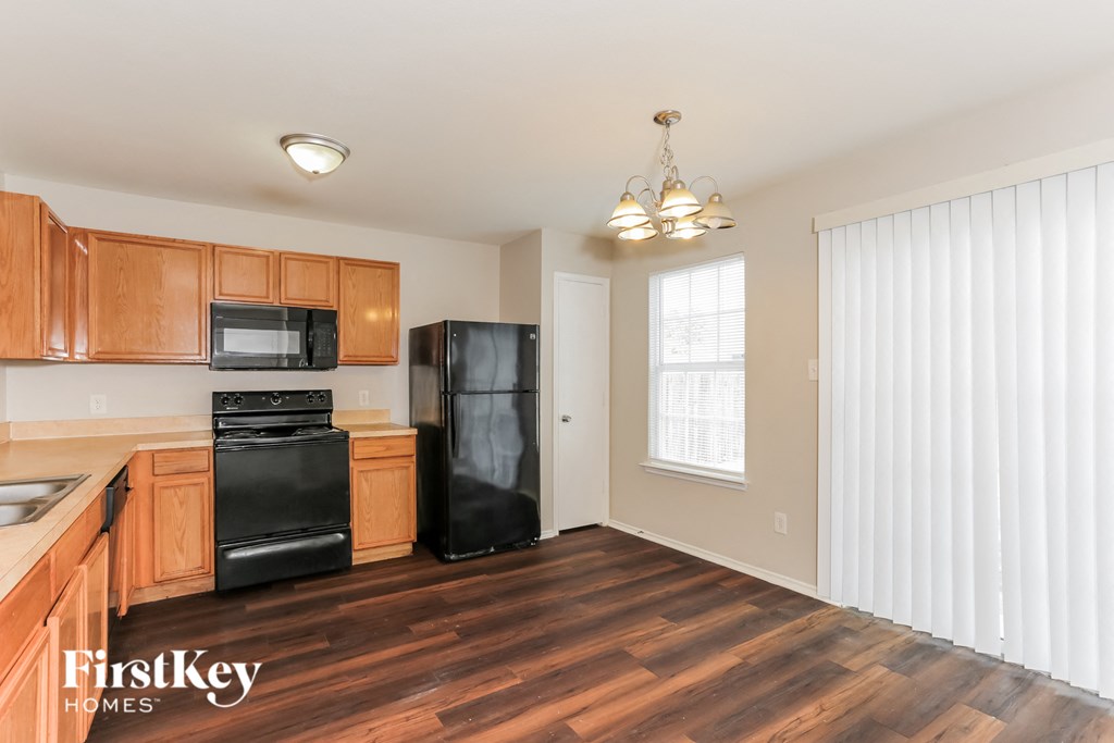 A kitchen with wooden cabinets and black appliances.