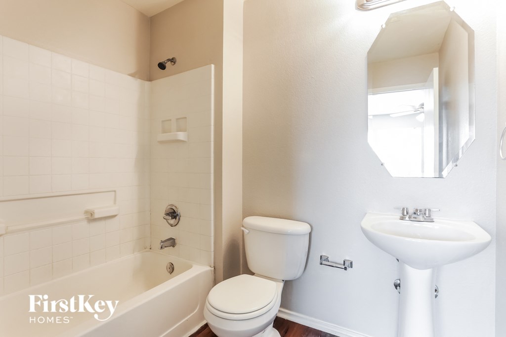 A white bathroom with a toilet, sink, and bathtub.