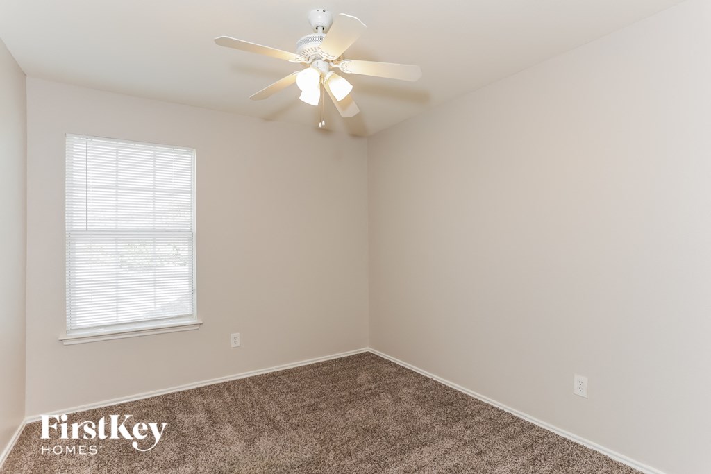 A room with a fan and a window.