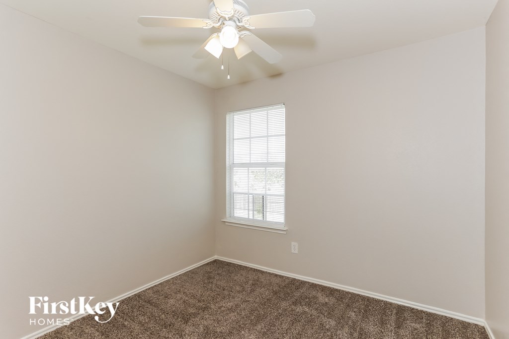 A room with a ceiling fan and a window.