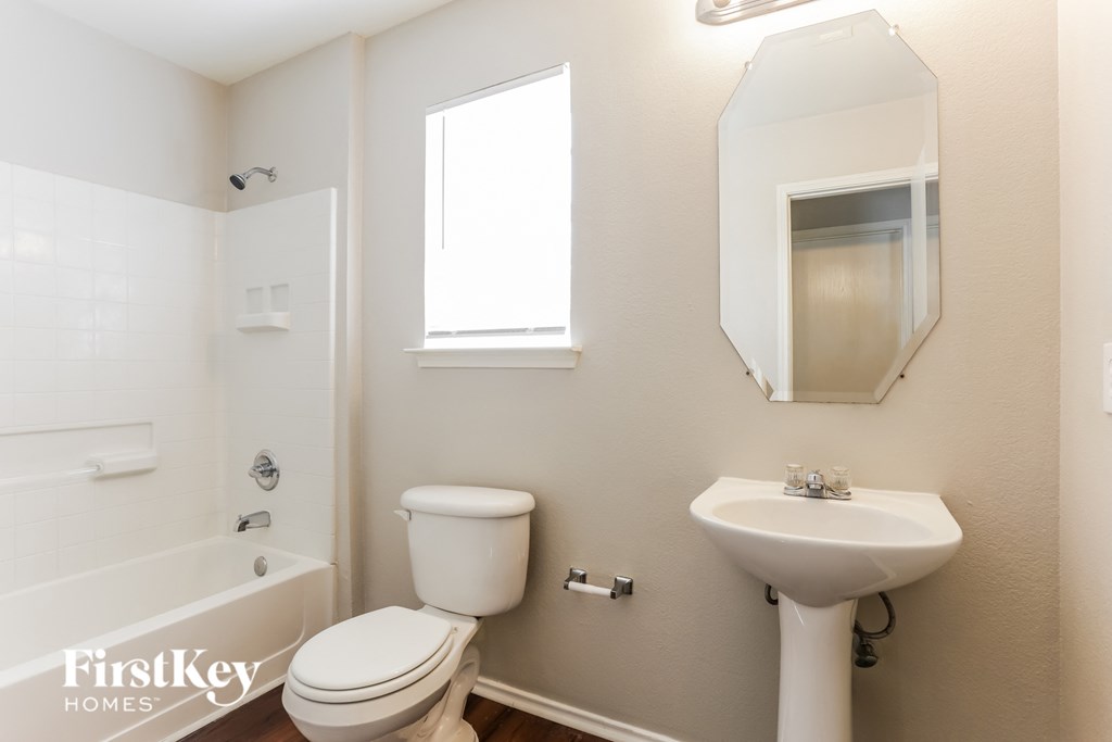 A white toilet sits next to a sink in a bathroom.