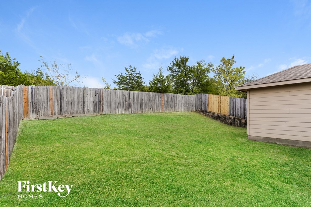 A backyard with a wooden fence and a shed.