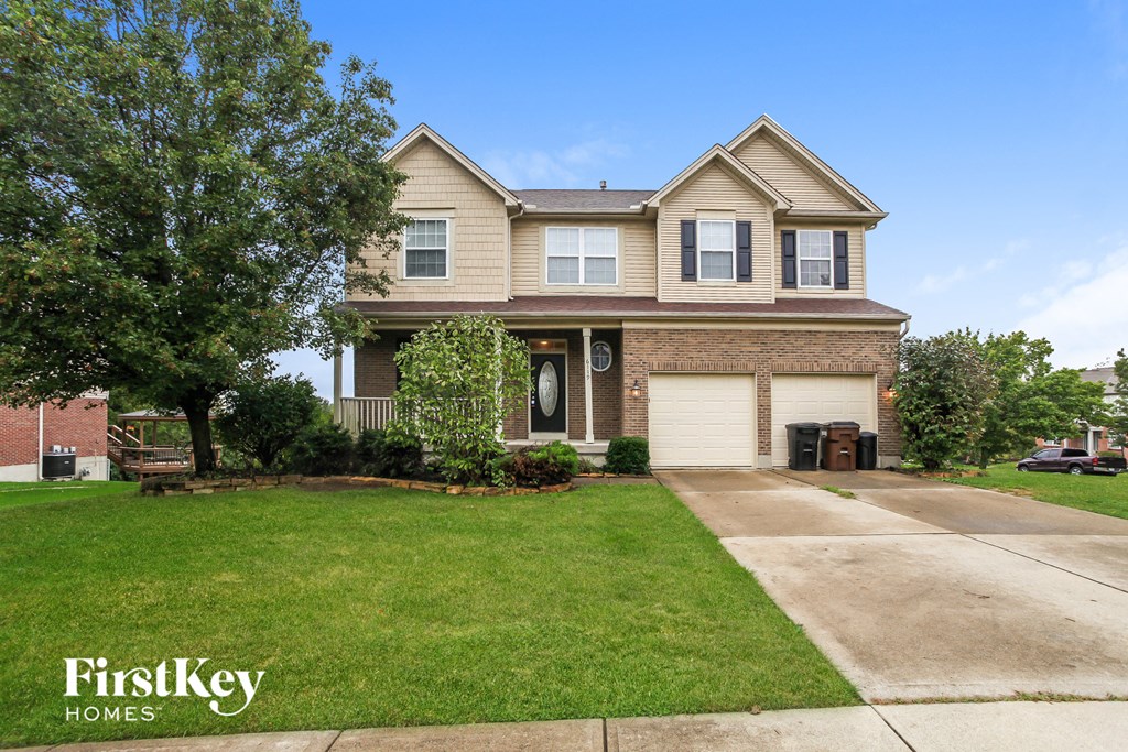 the front of a house with a lawn and a driveway