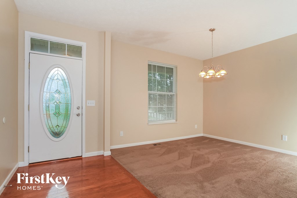a living room with a door with a window and a carpet