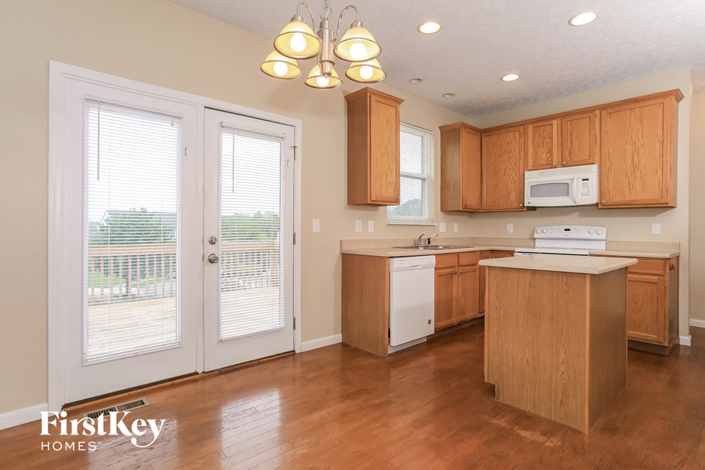 a kitchen with wooden cabinets and a door to a balcony