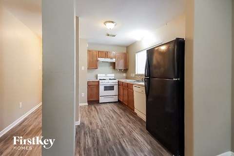a kitchen with wood flooring and a black refrigerator