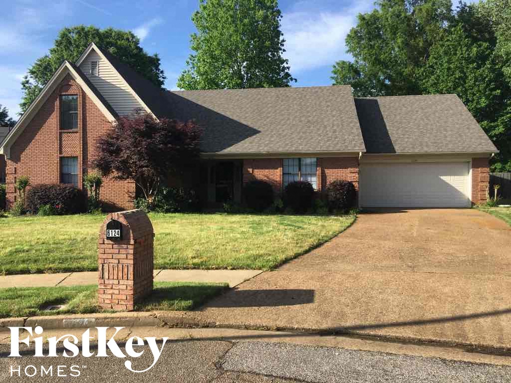 A brick house with a driveway and a mailbox in front of it.