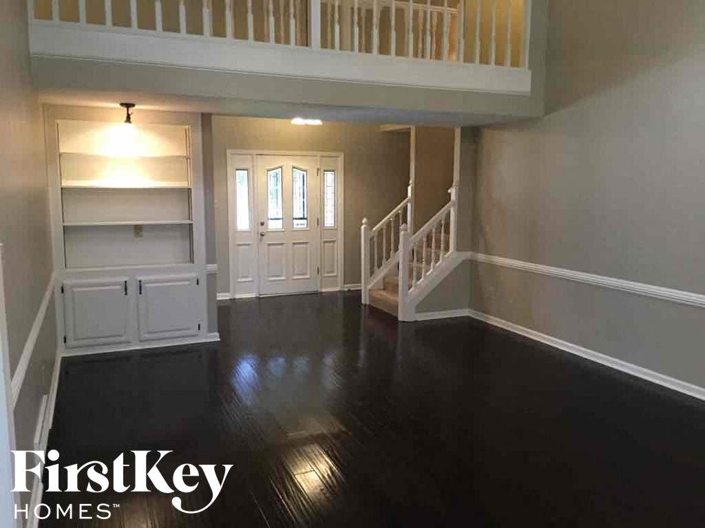 A spacious room with a staircase leading to the upper floor.