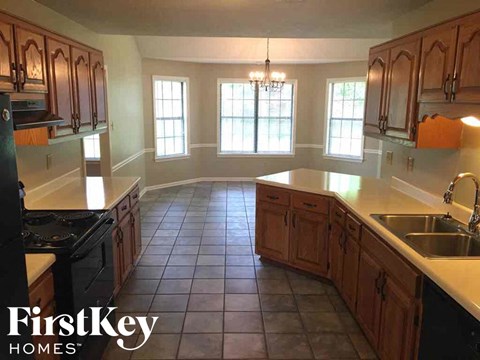 A kitchen with wooden cabinets and a black stove top oven.