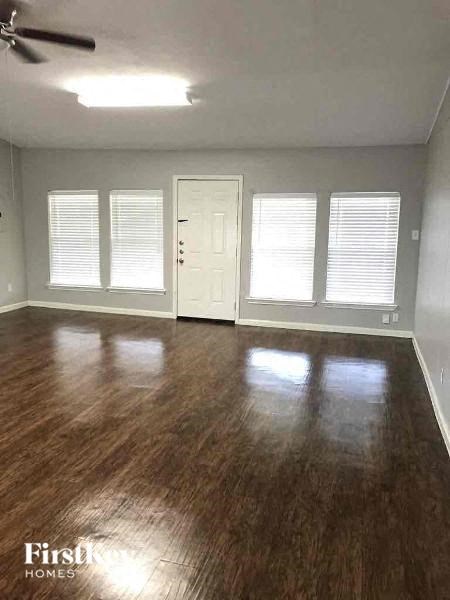 A room with wooden flooring and a ceiling fan.