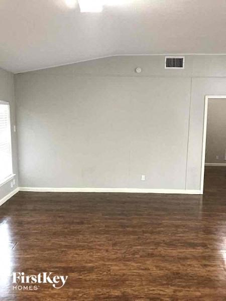 A room with wooden flooring and a white wall.