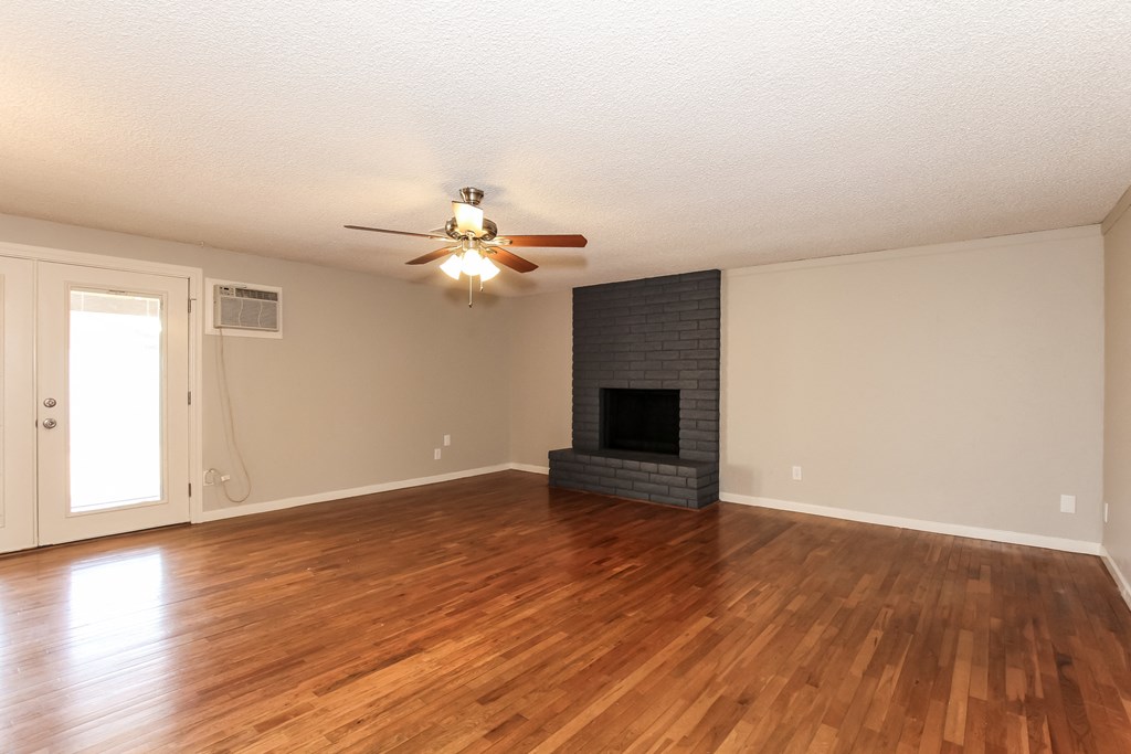 A room with a fireplace and a ceiling fan.