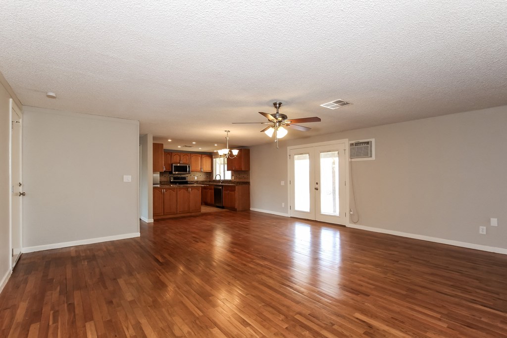 A room with wooden floors and a ceiling fan.