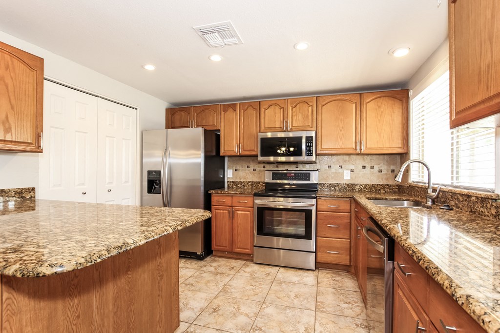 A kitchen with granite countertops and stainless steel appliances.