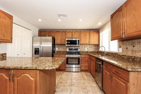 A kitchen with wooden cabinets and granite countertops.