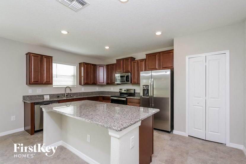 A kitchen with a granite countertop and stainless steel appliances.