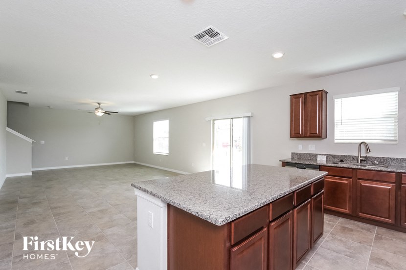 A kitchen with a marble countertop and wooden cabinets.