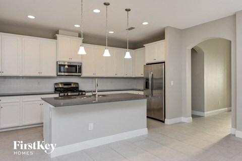 A kitchen with a stove top oven and a refrigerator.