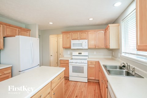 A kitchen with wooden cabinets and a white refrigerator.