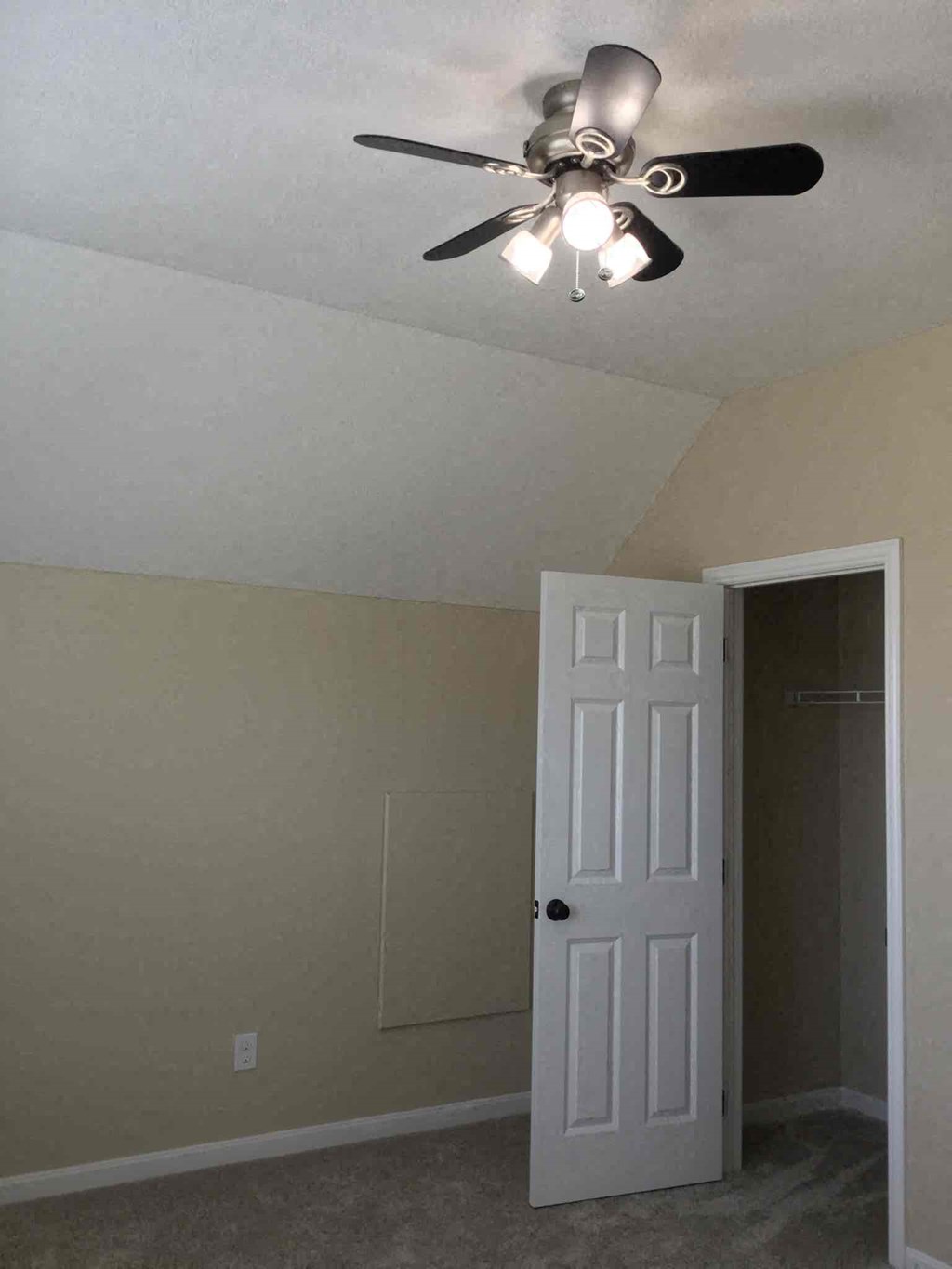 a bedroom with a ceiling fan and a door to a closet
