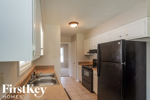 a kitchen with a black refrigerator and a sink