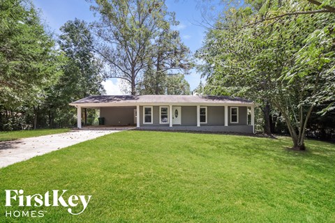 a small house with a lawn and trees