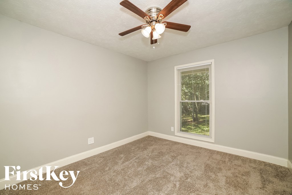 a bedroom with a ceiling fan and a window