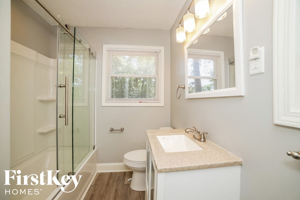 a bathroom with a shower toilet and sink and a mirror