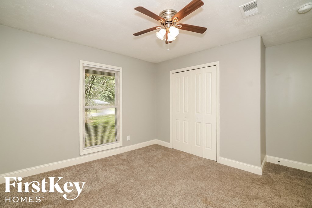 a bedroom with a ceiling fan and a window